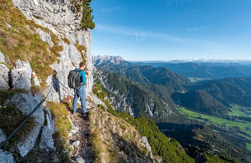 Hiker on hiking trail with steel cable