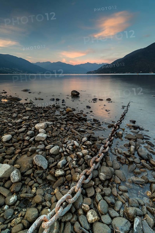 Rusty chain on gravel leads into the water