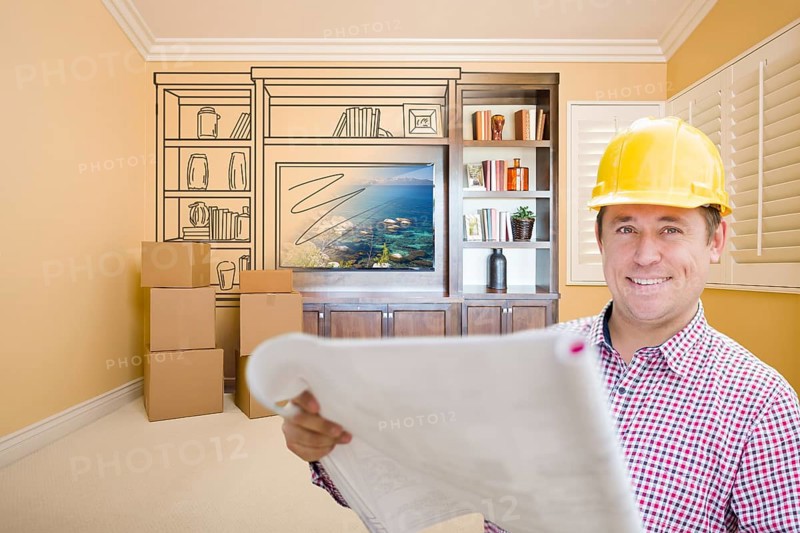 Male construction worker wearing hard hat in room with drawing of entertainment unit on wall
