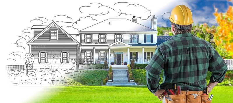 Male contractor with hard hat and tool belt looking at custom house drawing photo combination on white