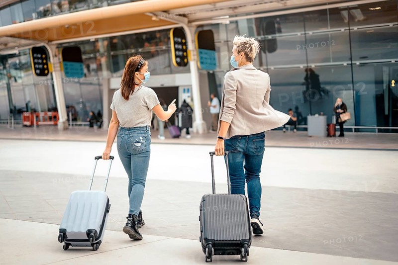Female friends with luggage approaching the airport ready for the trip