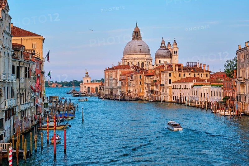Panorama of Venice Grand Canal with boats and Santa Maria della Salute church on sunset from Ponte dell'Accademia bridge. Venice