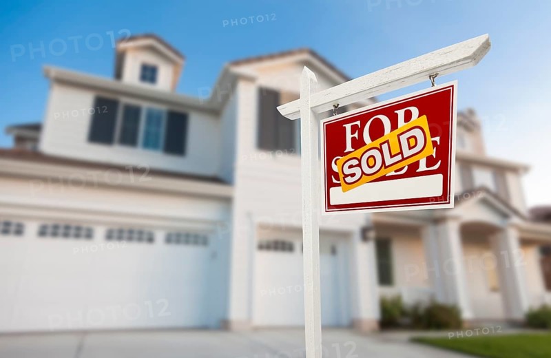 Sold home for sale real estate sign in front of beautiful new house