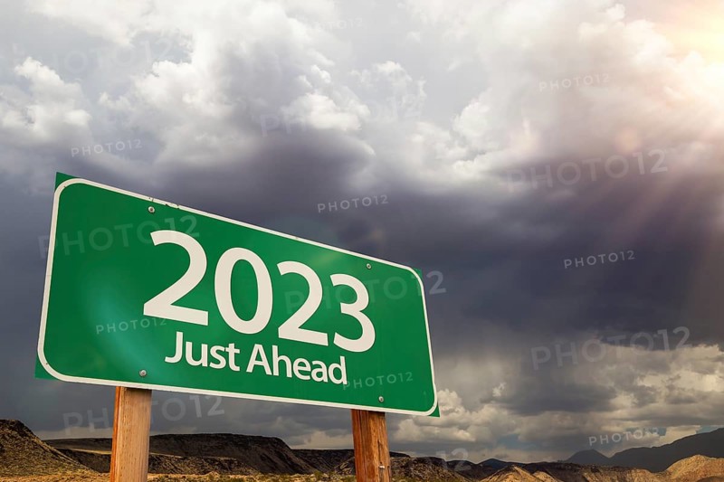 2023 green road sign over dramatic clouds and sky