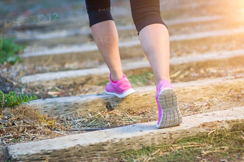 Young fit adult woman outdoors walking or running up wooden steps