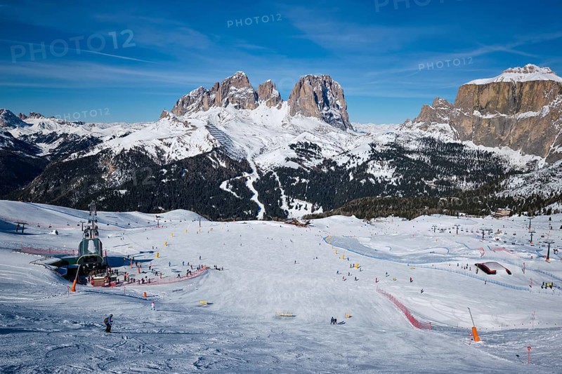 View of a ski resort piste with people skiing in Dolomites in Italy
