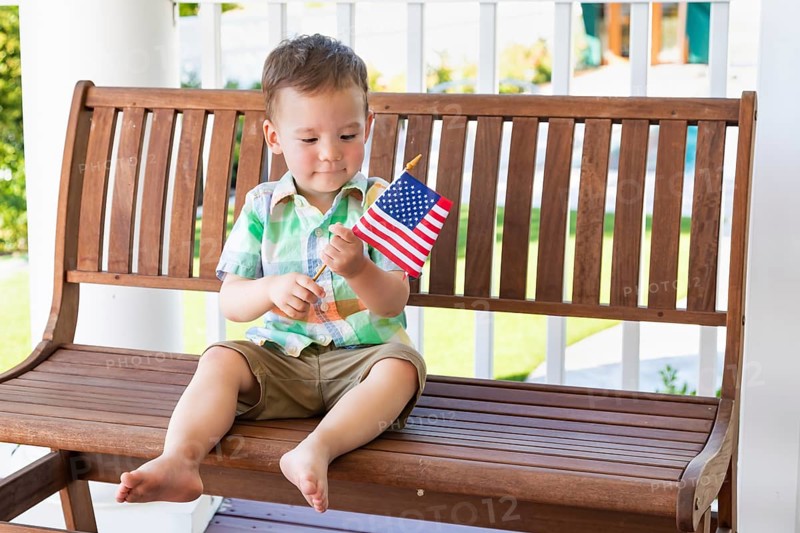 Young mixed-race chinese and caucasian boy playing with american flag