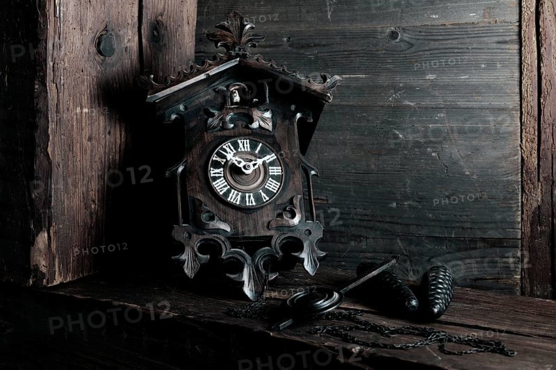 Antique Black Forest cuckoo clock on wooden background