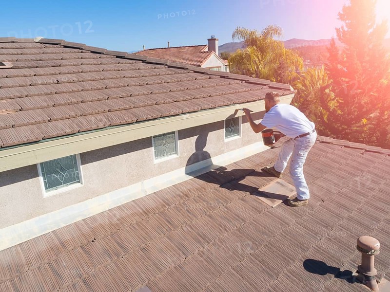 Professional painter using A brush to paint house facade