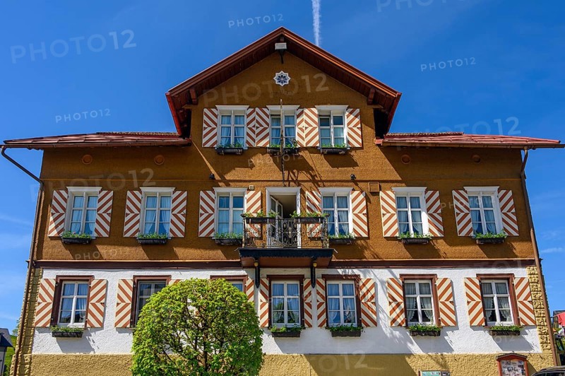 Wooden shingle facade with striped shutters