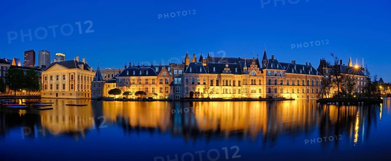 Panorama of the Binnenhof House of Parliament and Mauritshuis museum and the Hofvijver lake illuminated in the night. The Hague