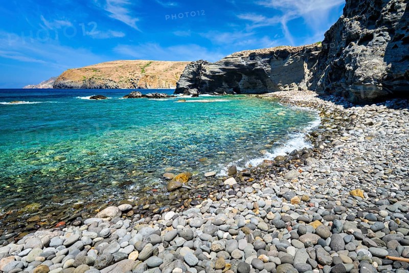 Papafragas beach with crystal clear turquoise water and tunnel rock formations in Milos island