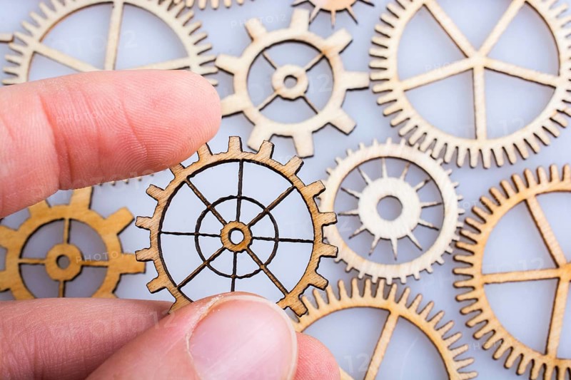 Hand holding gear wheels as the concept of mechanism