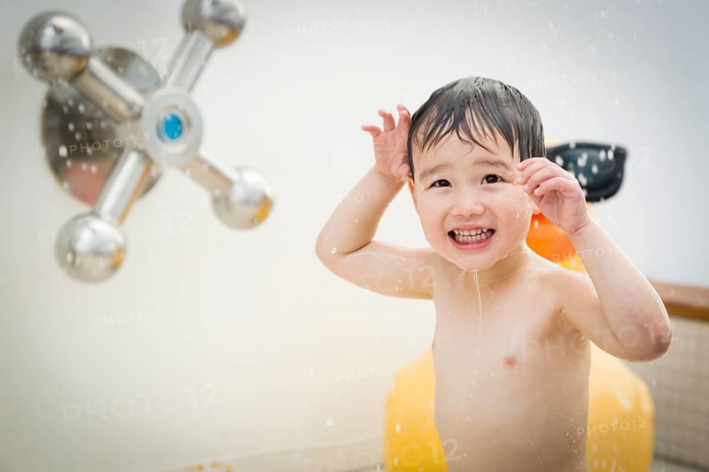 mixed-race boy having fun at the water park with large rubber duck in the background