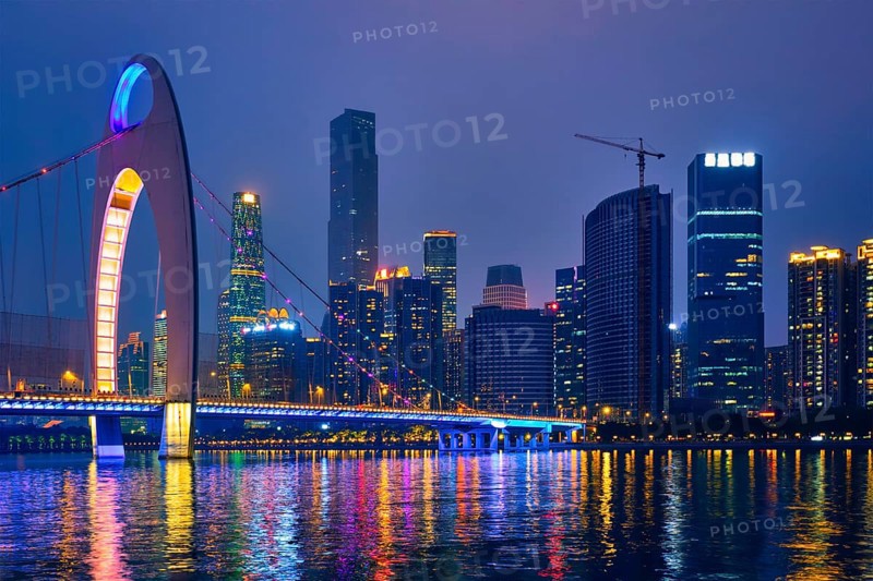 Guangzhou cityscape skyline over the Pearl River with Liede Bridge illuminated in the evening. Guangzhou