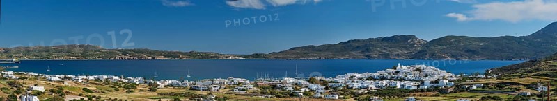 Panorama of Plaka village with traditional Greek church white painted Greek houses and ocean coast. Milos island