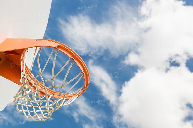 Abstract of community basketball hoop and net against blue sky