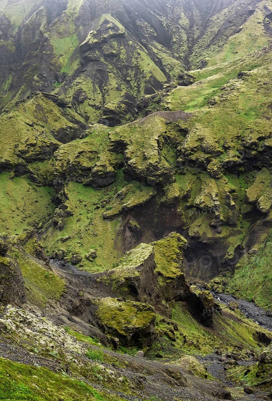 View into rugged moss-covered canyon with tufa rock formations