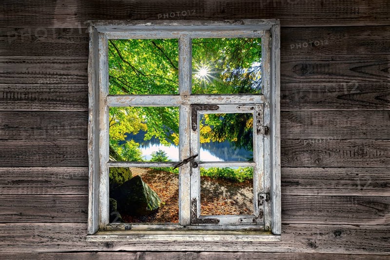 View through a rustic wooden window onto the Feldsee