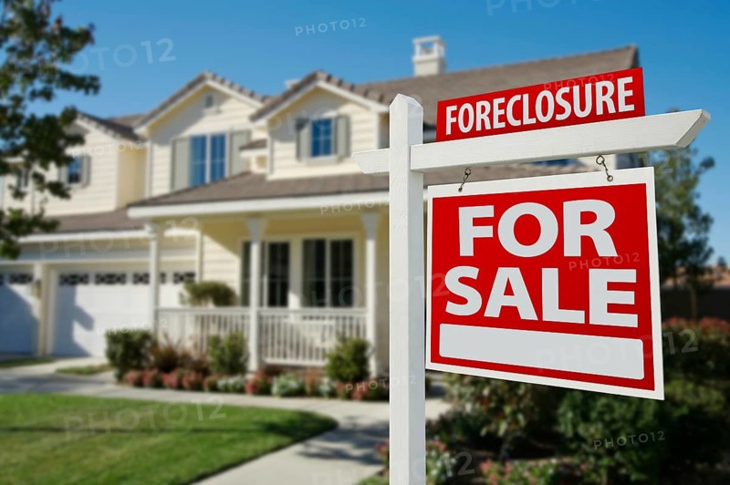 Foreclosure home for sale real estate sign in front of new house