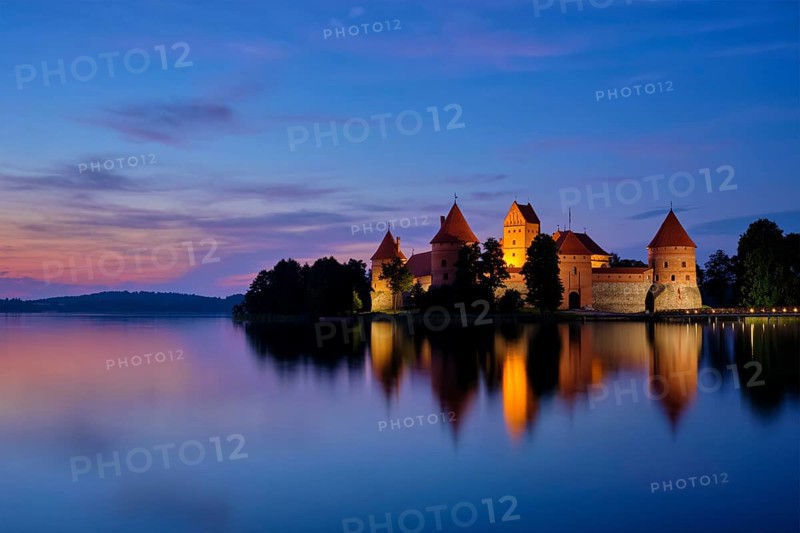 Night view of Trakai Island Castle in lake Galve illuminated in the evening reflecting in peaceful water