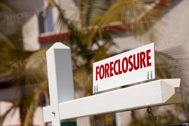 Close-up foreclosure real estate sign in front of house