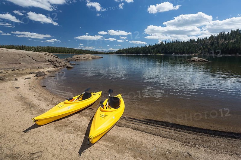 Pair of yellow kayaks on a beautiful mountain lake shore