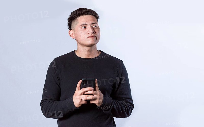 Thoughtful man with cell phone in hand