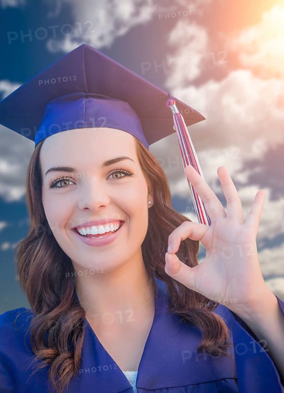 Happy graduating mixed-race woman in cap and gown
