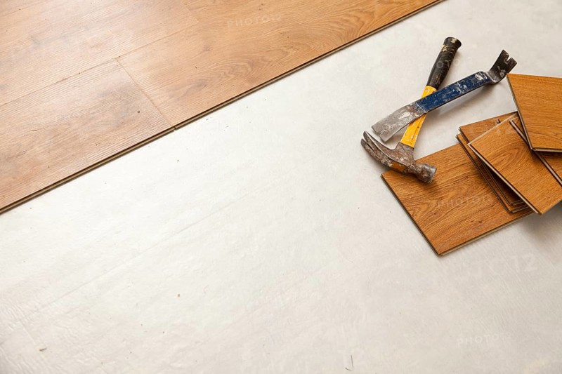 Worn hammer and pry bar with laminate flooring abstract with copy room