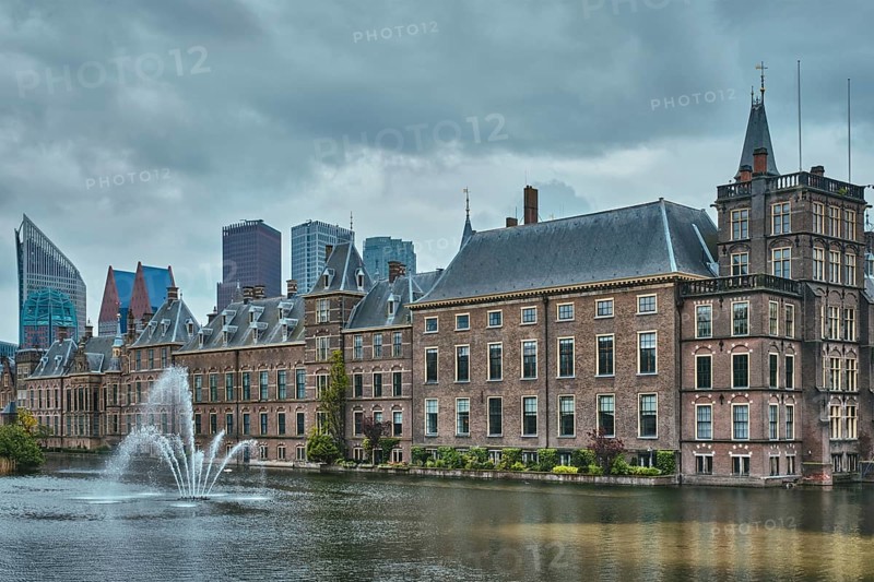 View of the Binnenhof House of Parliament and the Hofvijver lake with downtown skyscrapers in background