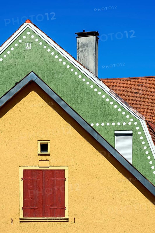 Orange Fassade und Dach mit Bieberschwanzziegeln