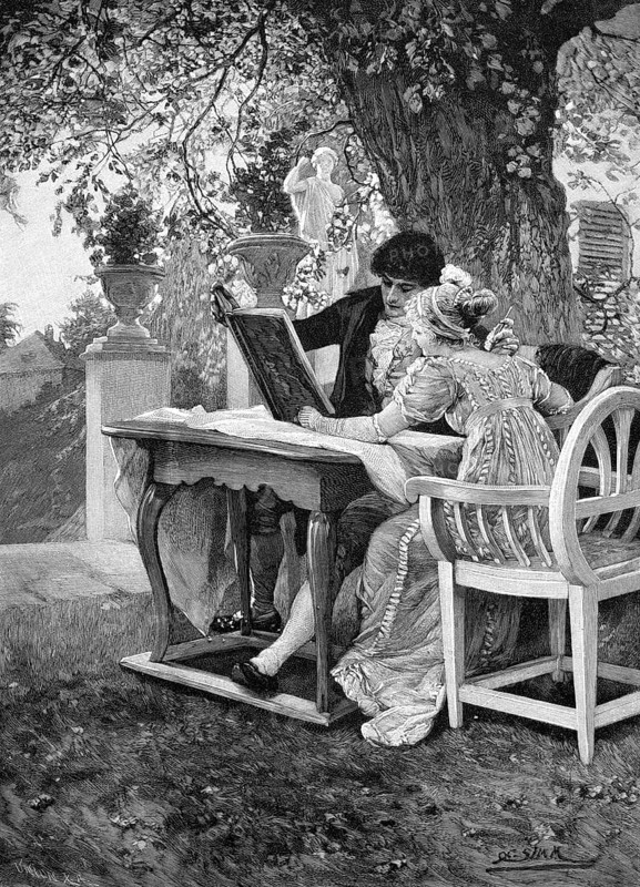 Young couple with a book in the garden under a lime tree