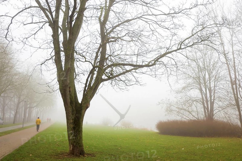 Stroller in the morning fog on the Hiroshima bank on the Fulda with pickaxe