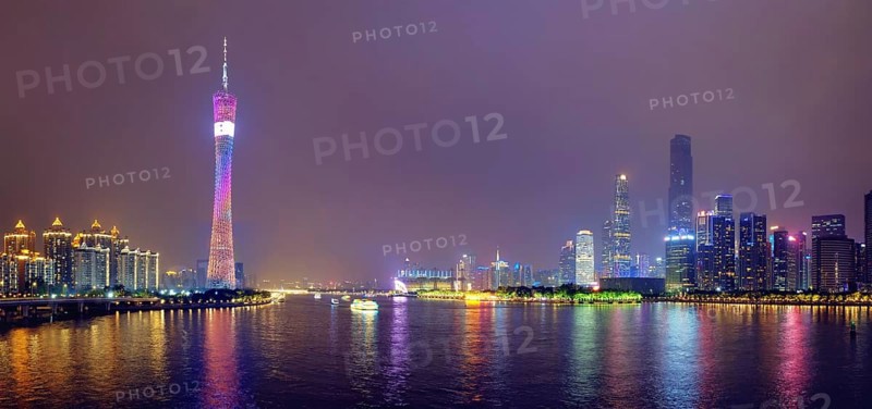 Guangzhou cityscape skyline ver the Pearl River illuminated in the evening panorama