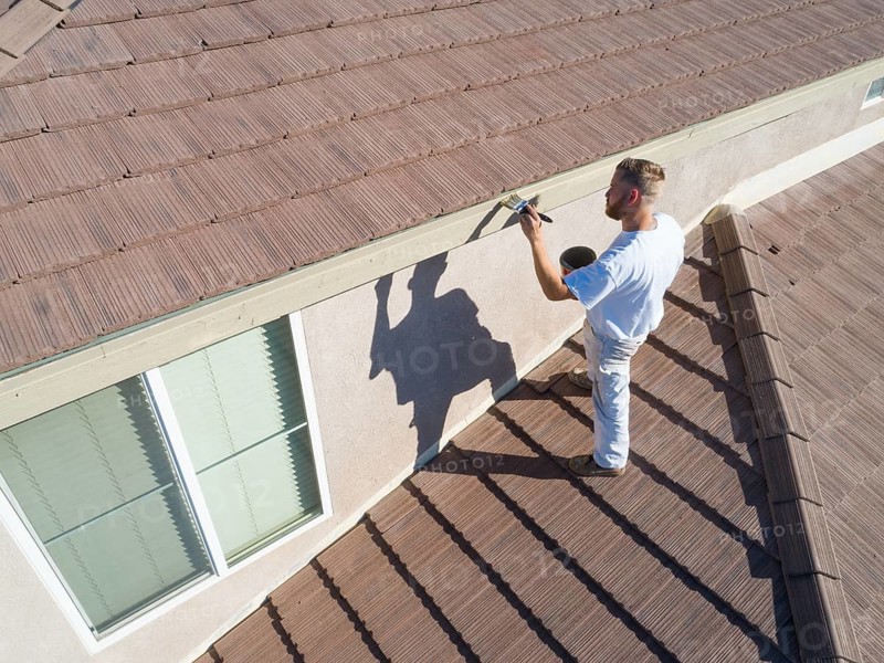 Professional painter using A brush to paint house facade