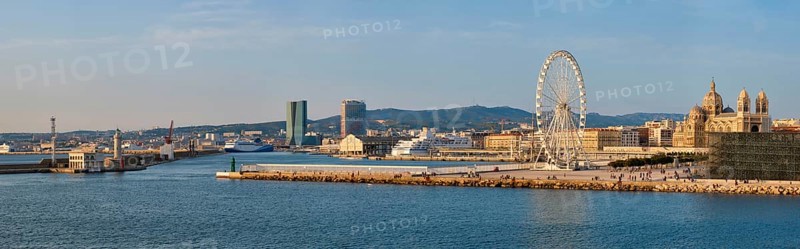 Panorama of Grande Roue de Marseille Ferris wheel and Marseille cathedral and port of Marseille on sunset