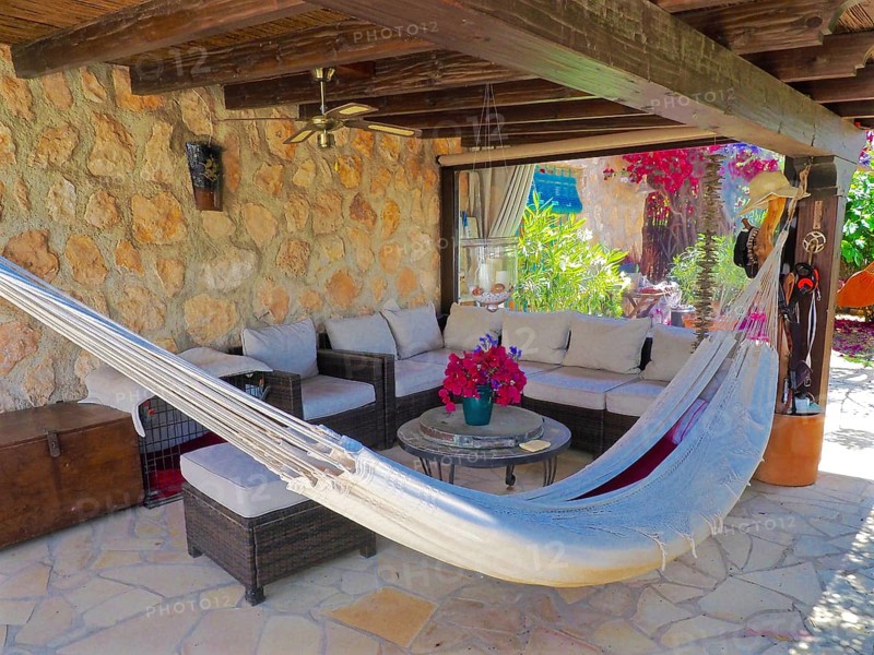 Covered wooden veranda with seating area and hammock
