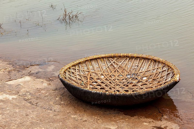 Traditional wickerwork coracle boat in Hampi on bank of Tungabhadra river