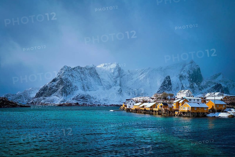 Yellow rorbu houses of Sakrisoy fishing village with snow in winter. Lofoten islands