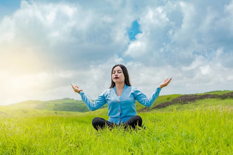 Girl sitting doing meditation yoga in the field