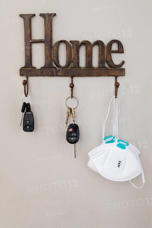 Home key hanger rack next to door with keys and medical face mask during coronavirus pandemic