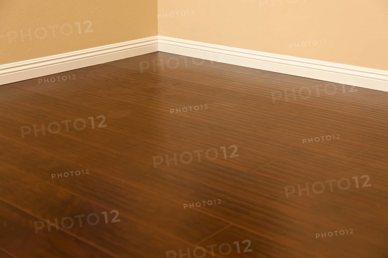 Beautiful newly installed brown laminate flooring and baseboards in home