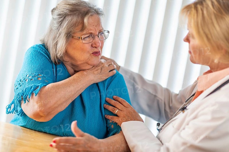 Senior adult woman talking with female doctor about sore shoulder