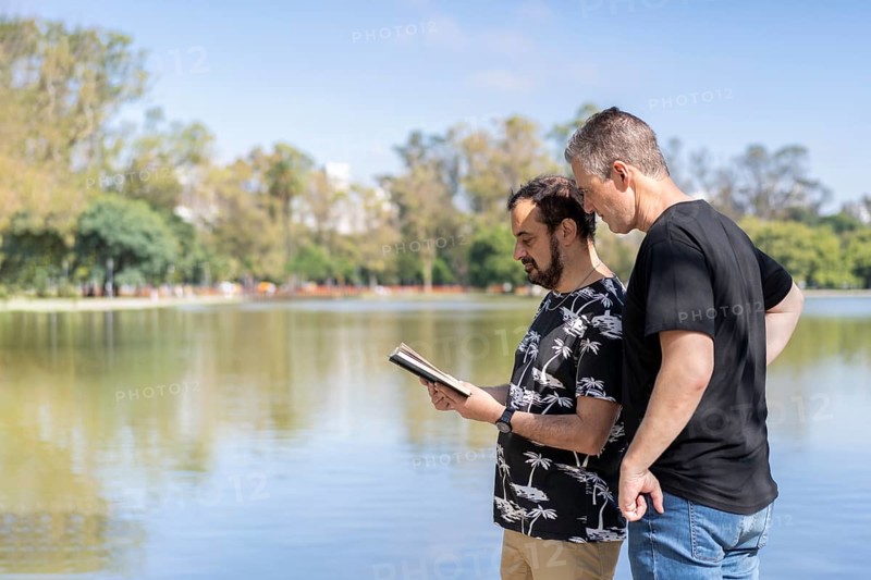 Couple of mature men reading in a lake