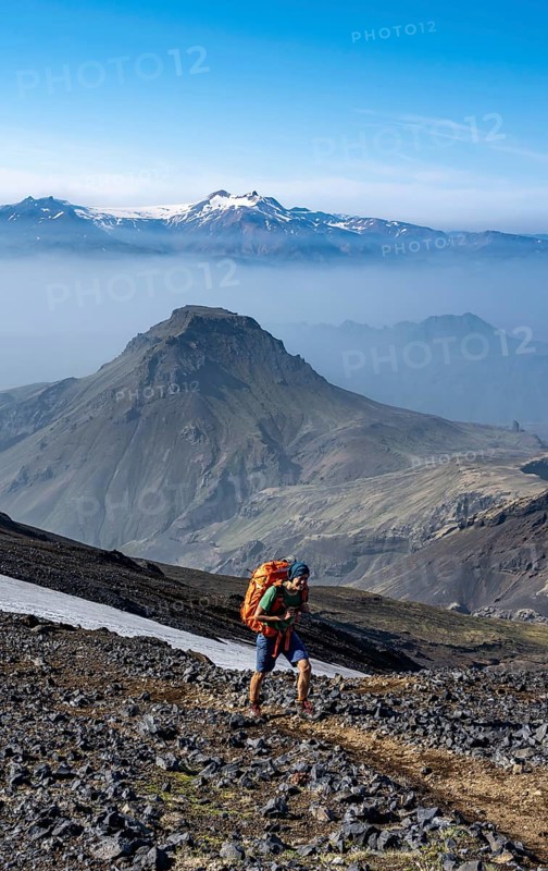 Hikers on trail through volcanic landscape