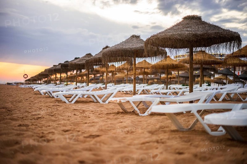 Beautiful colorful sunset over sun beds and umbrellas in Vilamoura