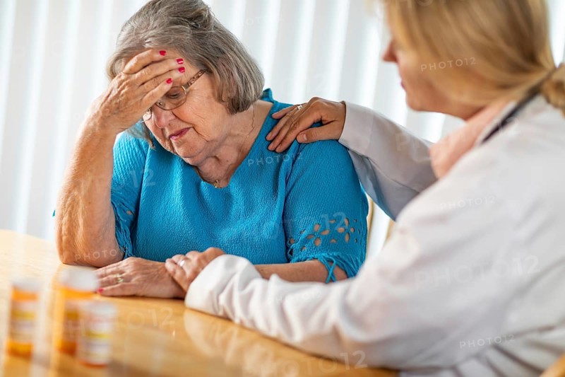 Female doctor consoling distraught senior adult woman