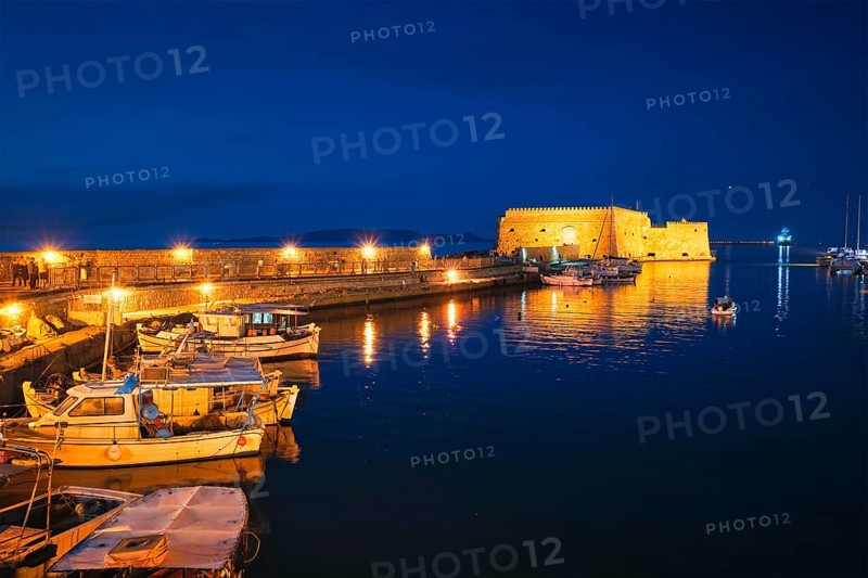 Venetian Fort castle in Heraklion and moored Greek fishing boats in port