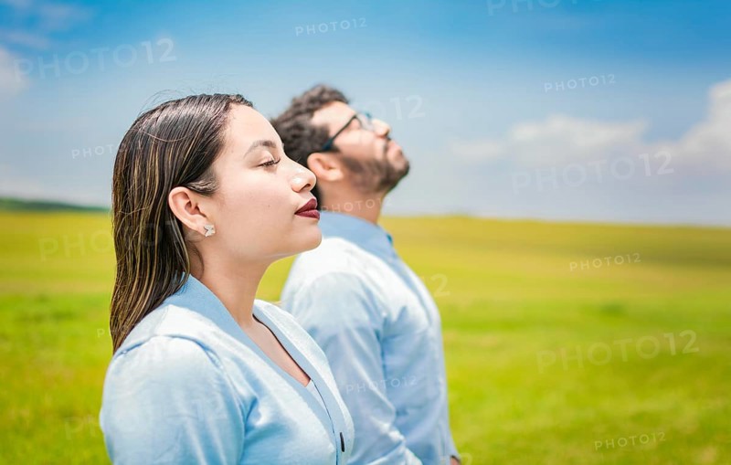 Young couple breathing fresh air in the field